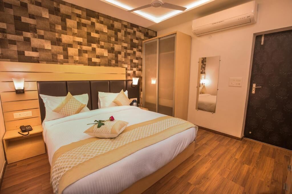 Ein Hotelzimmer mit einem großen Bett, einem Holzkopfstück und einem Kleiderschrank.