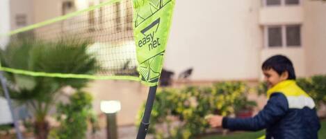 Una cancha de bádminton con una red y un logotipo en el poste de la red.