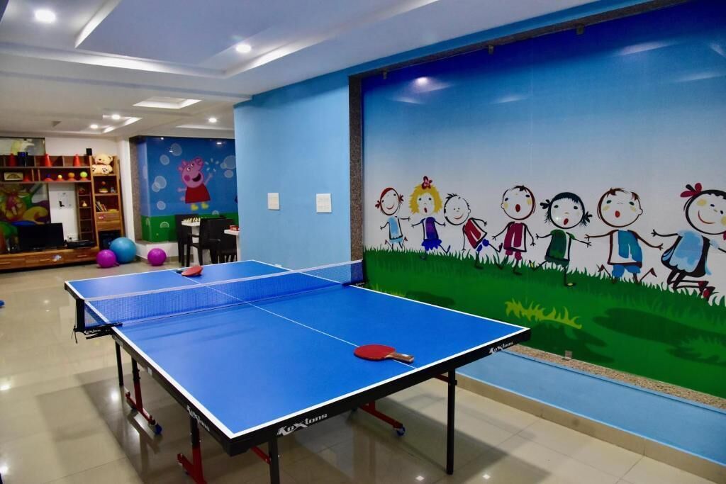 A ping pong table in a room with a children's mural on the wall.