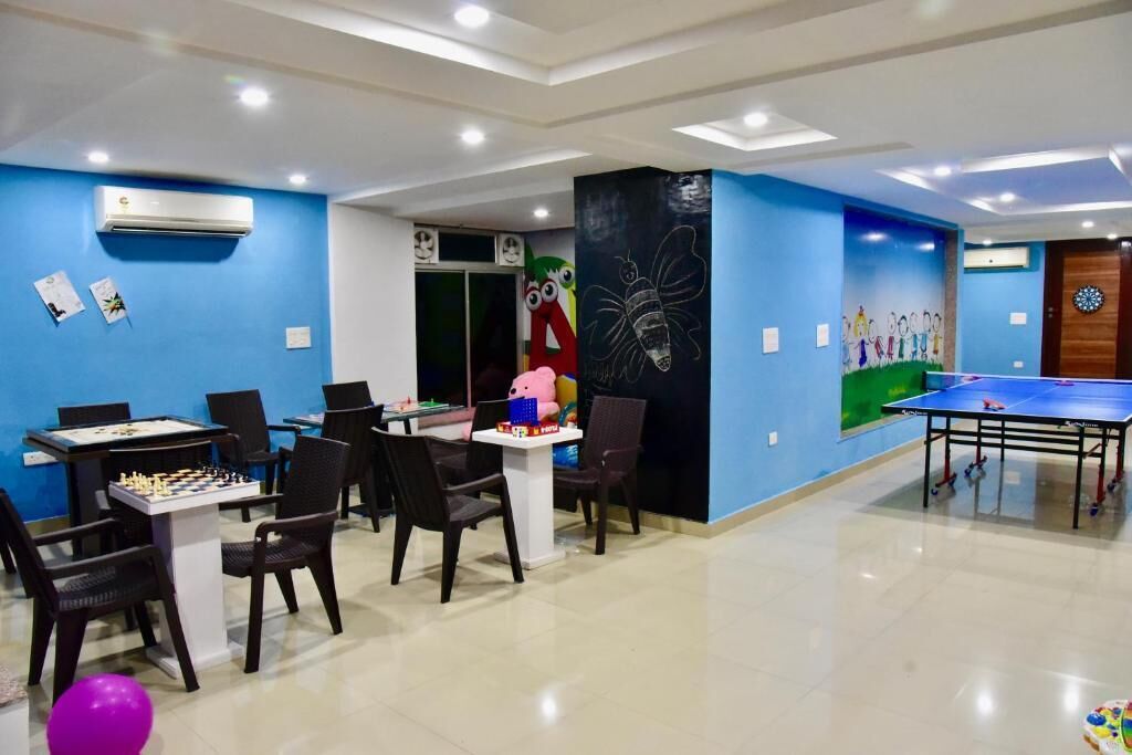 Una habitación con mesa de ping pong, mesa de fútbolín y mesa de ajedrez.