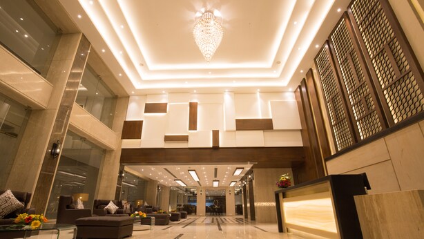 A spacious lobby with a modern chandelier, comfortable seating, and a clean, polished floor. - Hotel Kiscol Grands (Coimbatore)