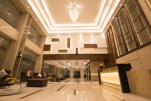 A spacious lobby with a modern chandelier, comfortable seating, and a clean, polished floor. - Hotel Kiscol Grands (Coimbatore)