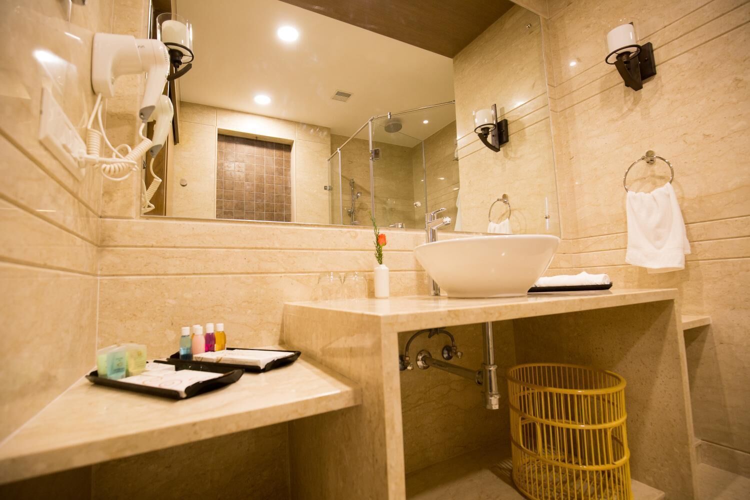 A modern bathroom with a large mirror, a sink, and a shower.
