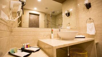 Un baño moderno con un lavamanos grande, un secador de pelo, un espejo y una ducha.