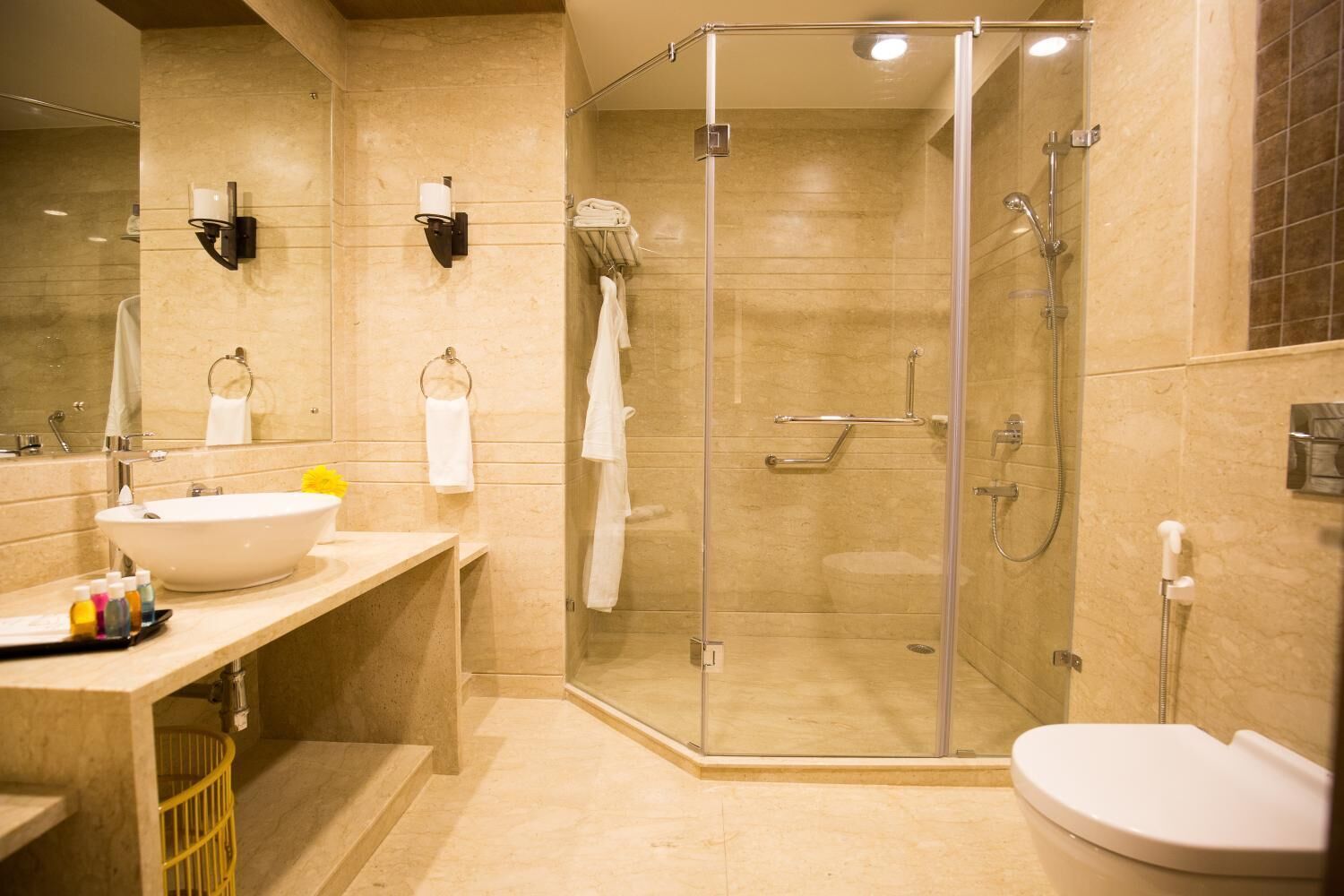A modern bathroom with a glass-enclosed shower, a white sink, and a toilet.