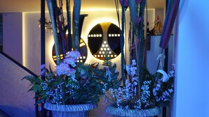 A staircase with two large, ornate planters with flowers and decorative plants. - Hotel Nancy (Rimini)