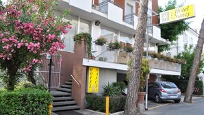 A hotel with a sign reading "Hotel Nancy" and a staircase leading to the entrance. - Hotel Nancy (Rimini)