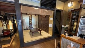 Ein traditioneller japanischer Raum mit Tatami-Böden, einem niedrigen Tisch und einer Schiebetür.