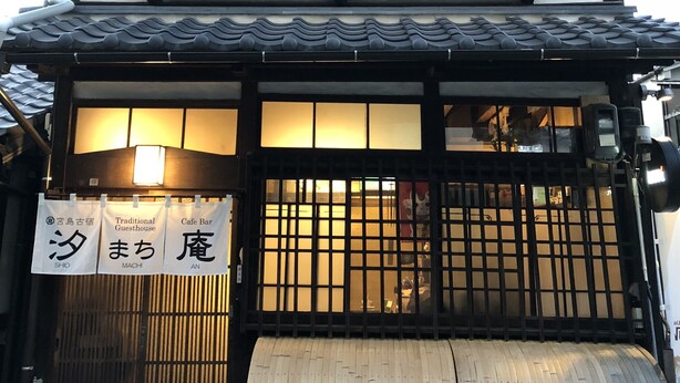 Ein traditionelles japanisches Gebäude mit einer zweistöckigen Struktur, einem Ziegeldach und einem hölzernen Tor.
