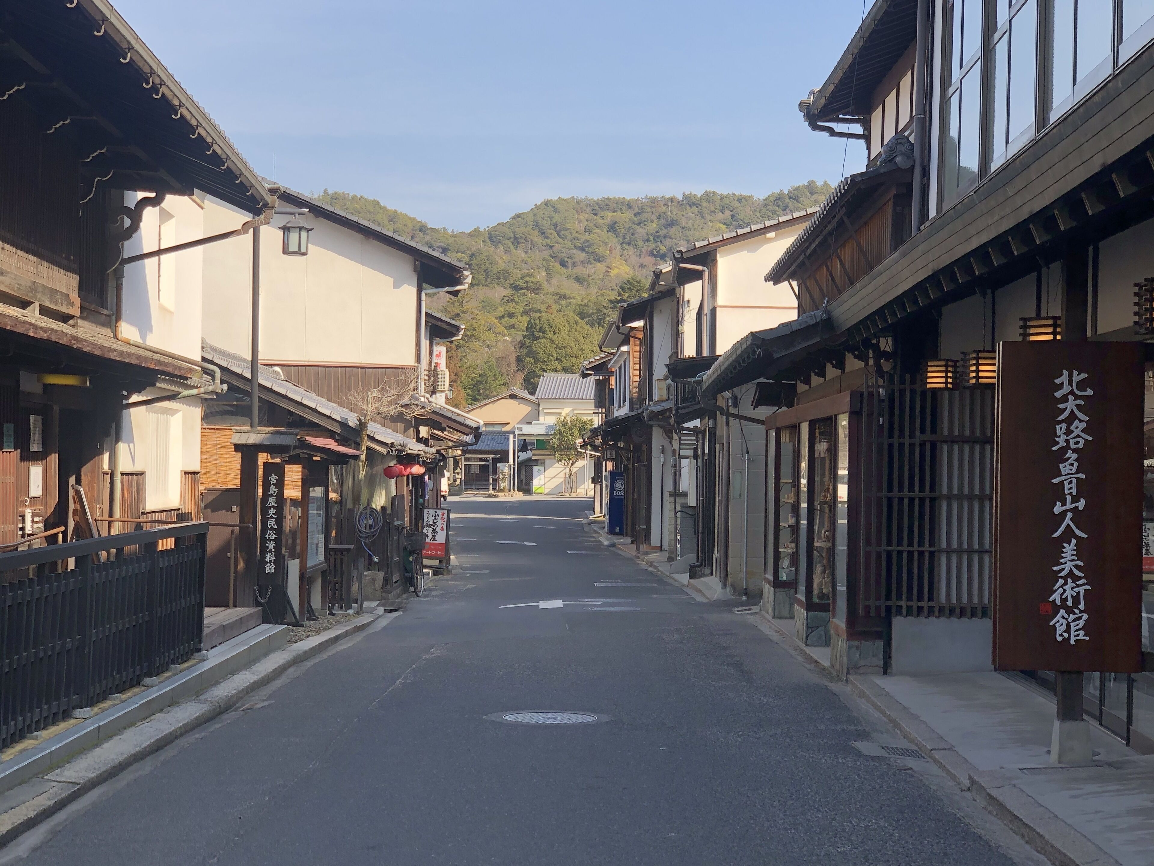 A narrow street lined with traditional buildings, some with signage indicating local businesses or services.