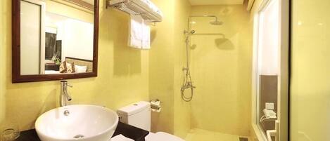 A compact bathroom with a white sink, toilet, and shower.