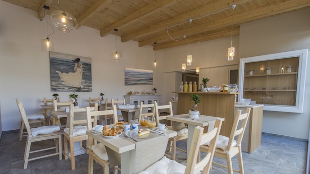 Una zona de menjador amb taules i cadires de fusta, una zona de bar amb prestatgeries i obres d'art a les parets.