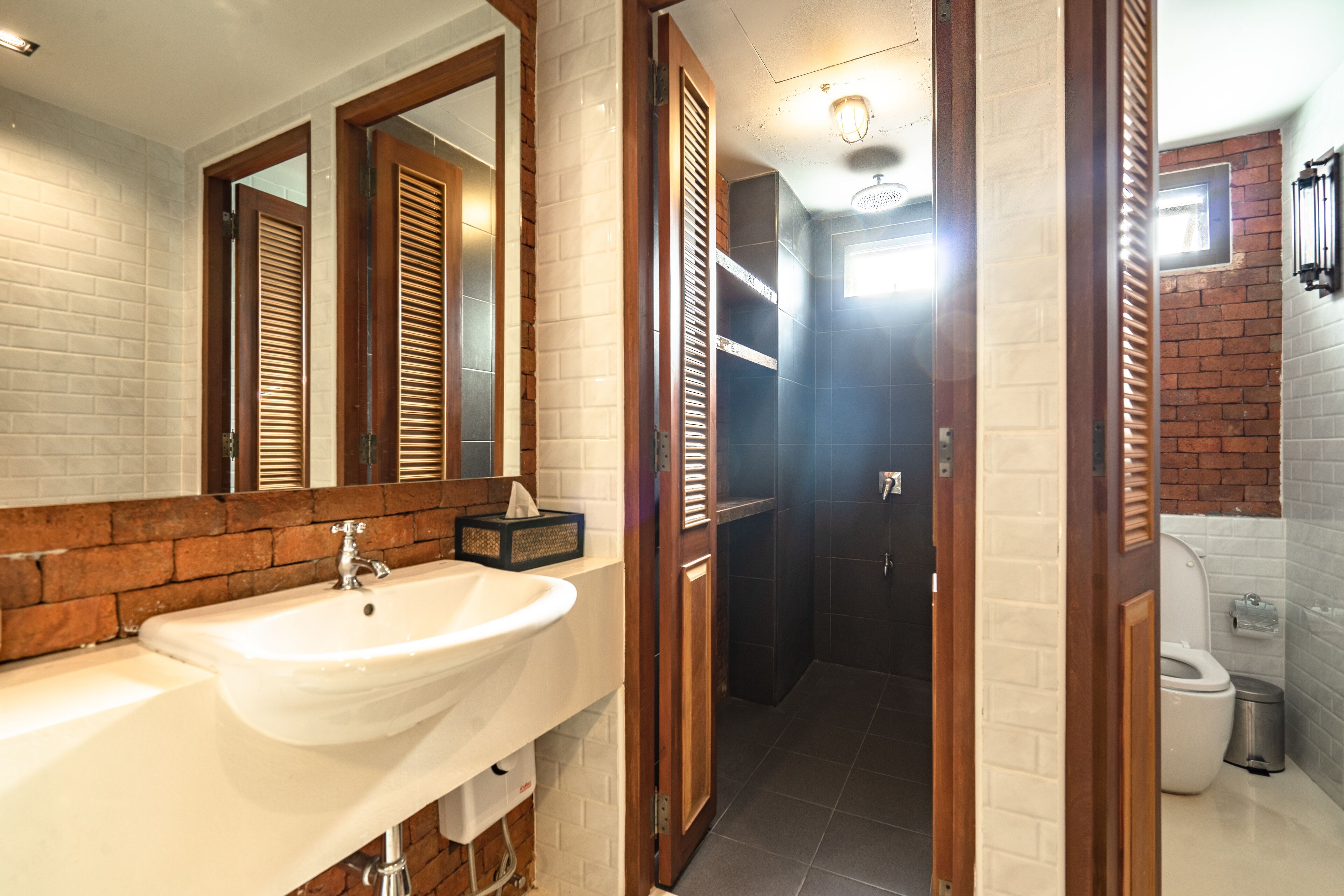 A bathroom with a white sink, wooden door, and a visible toilet.