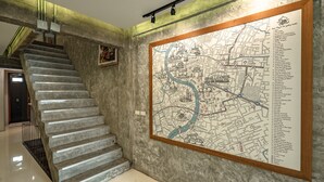 Un escalier en marbre menant à une carte encadrée d’une ville.