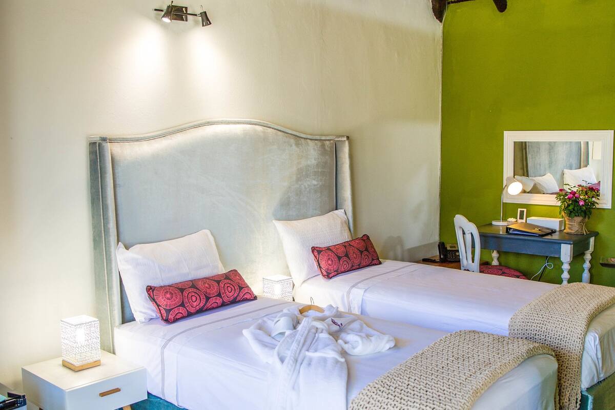 A spacious bedroom with a large bed, a desk, and a chair.