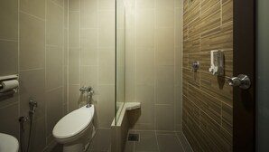 Een moderne badkamer met toilet, douche en douchecabine met glazen wanden.