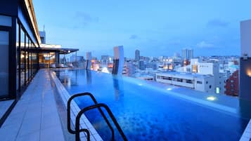 Enjoy unobstructed city views from our rooftop pool, surrounded by a seating area and sunshade.