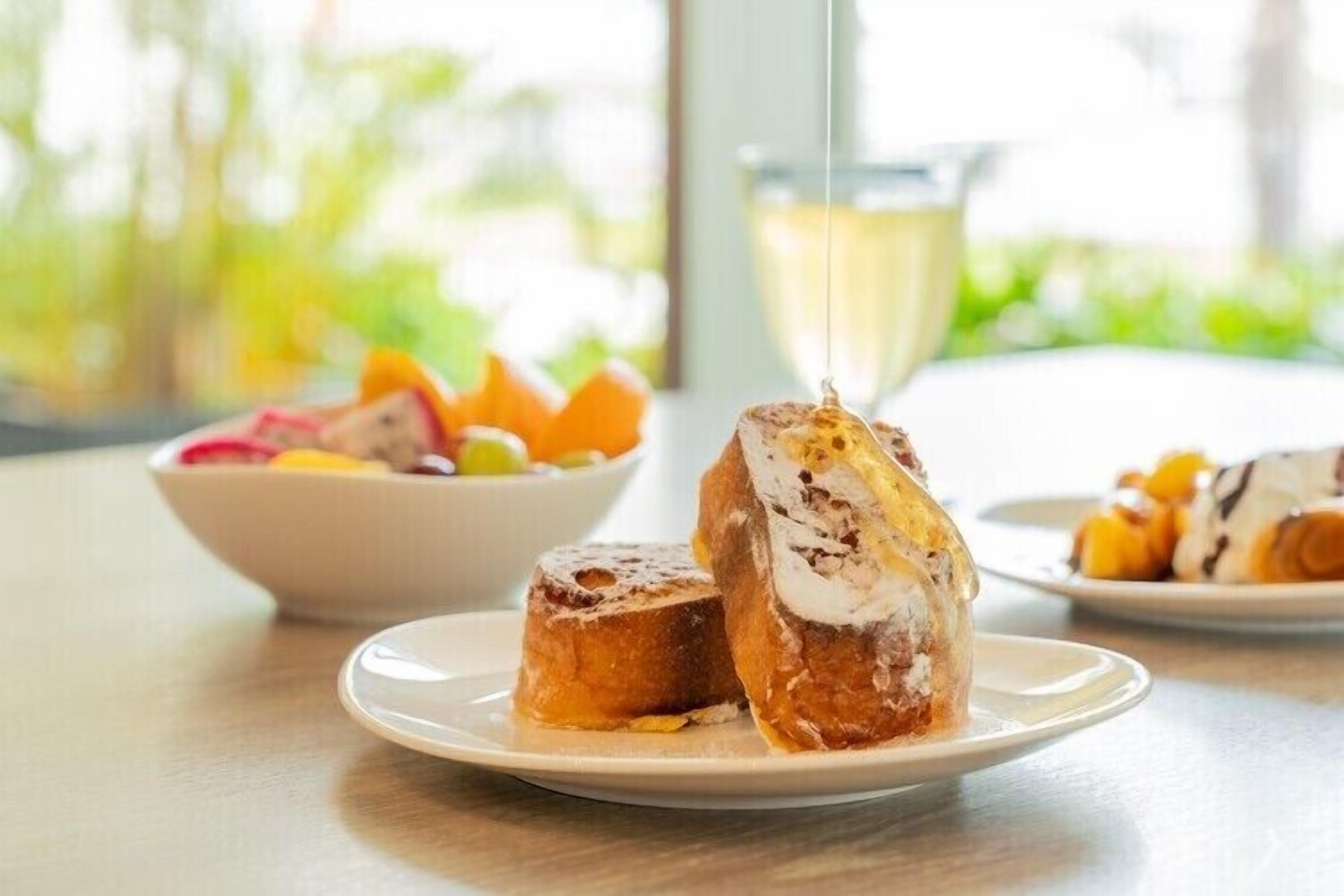 A breakfast setting with a plate of pastries and a bowl of fruit.