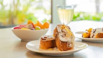 A breakfast setting with a plate of pastries and a bowl of fruit.
