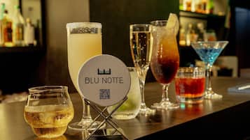 Zona de bar con diferentes bebidas y un cartel que dice "BLU NOTTE" con un código QR.