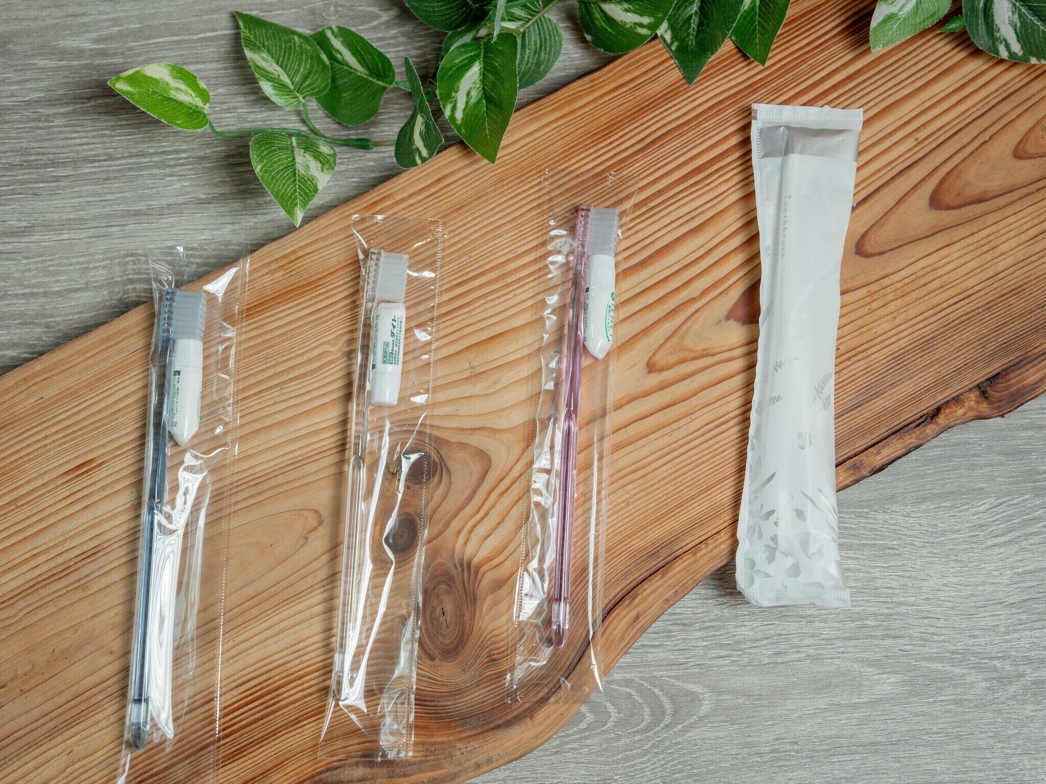 A wooden surface with various items in clear plastic packaging, including tubes and a roll of paper towels.