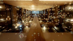 Un pasillo de hotel con un pasillo central y decoraciones con forma de burbujas.