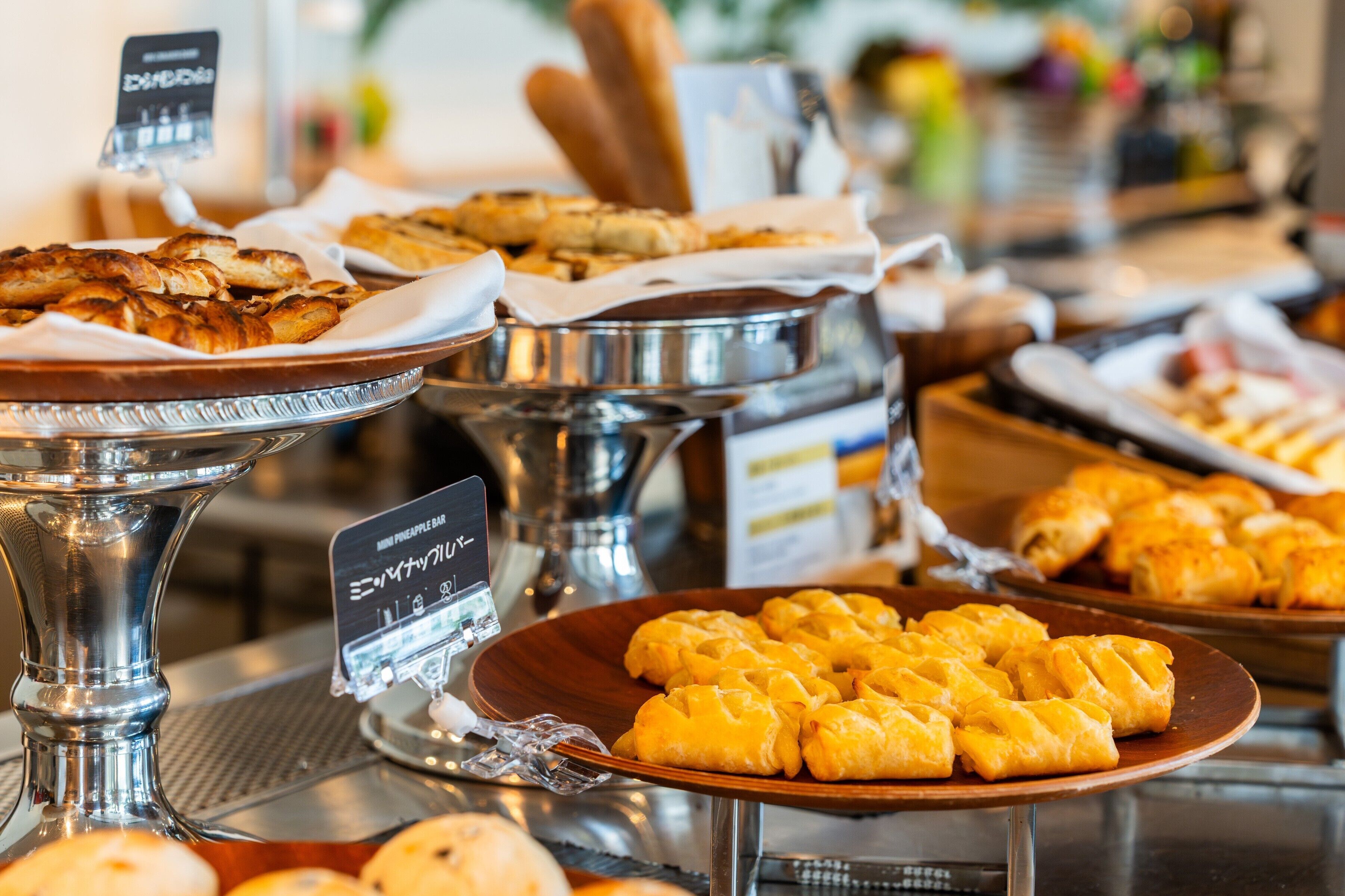A buffet with various baked goods including pastries and bread.