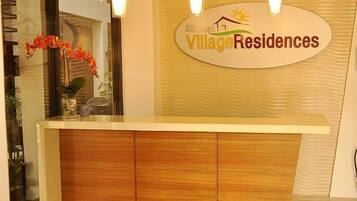 A reception desk with a sign reading "Rishan Village Residences".