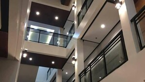 A multi-level interior with glass railings and multiple floors. - Rishan Village Residences (Angeles City)