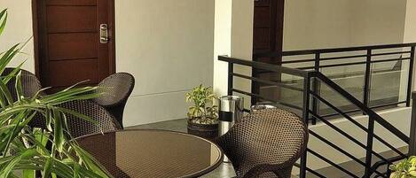 An outdoor seating area with wicker furniture and potted plants.
