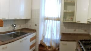 A kitchen with white cabinets, a sink, and a stove. - B&B In Centro (San Benedetto del Tronto)