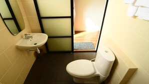 Ein kleines Badezimmer mit einem weißen Waschbecken, einer Toilette und einem Spiegel.