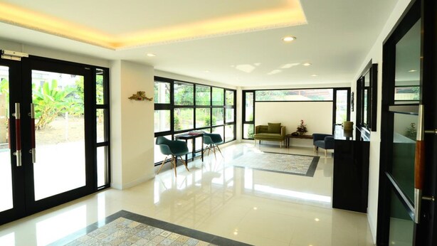 Ein großzügiges, modernes Interieur mit großen Fenstern, einem sauberen Boden und einem minimalistischen Design.