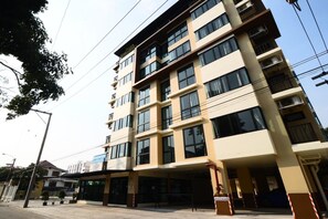 A multi-story hotel with a modern design, featuring a flat roof, large windows, and a ground-level entrance with a covered area. - Bangna 21 Residence (Bangkok)