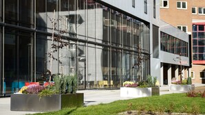 Un edificio moderno con amplias ventanas y un césped cuidado.