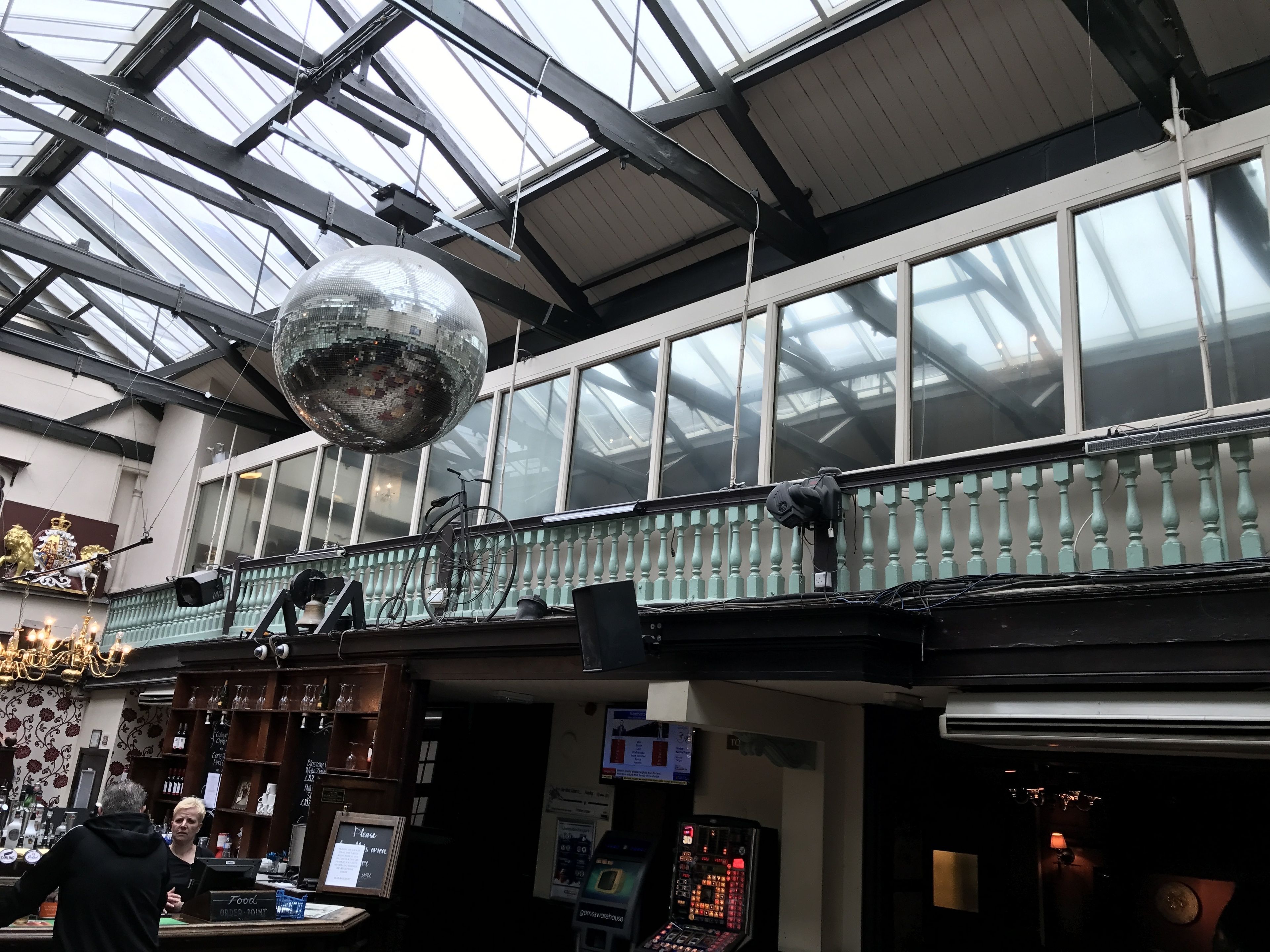 A spacious atrium with a high ceiling, large windows, and a disco ball.