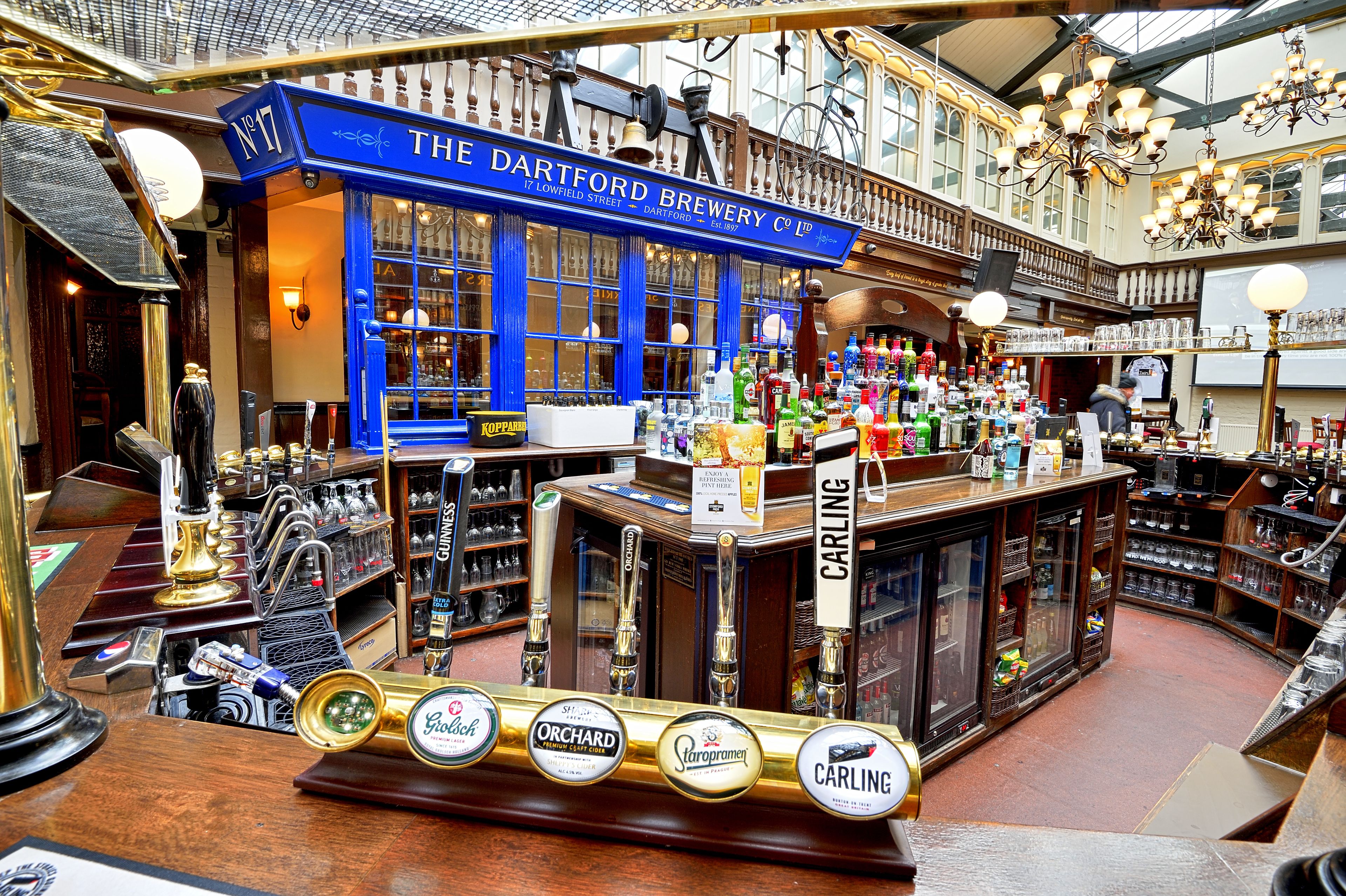 A bar with multiple beer taps and a variety of bottles.