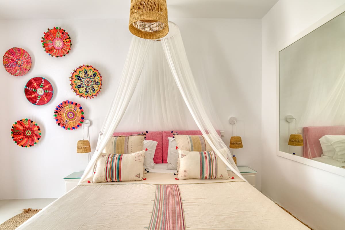Un dormitorio con cama con dosel, adornos en la pared y un espejo grande.