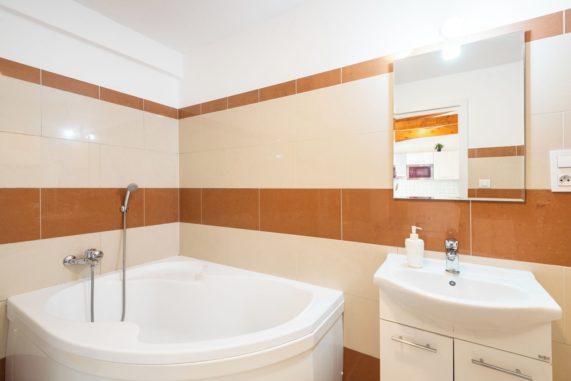 A modern bathroom with a bathtub, a sink, and a mirror.