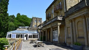 A historic building with a conservatory, outdoor seating, and classical architecture. - Accommodation at Salomons Estate (Royal Tunbridge Wells)