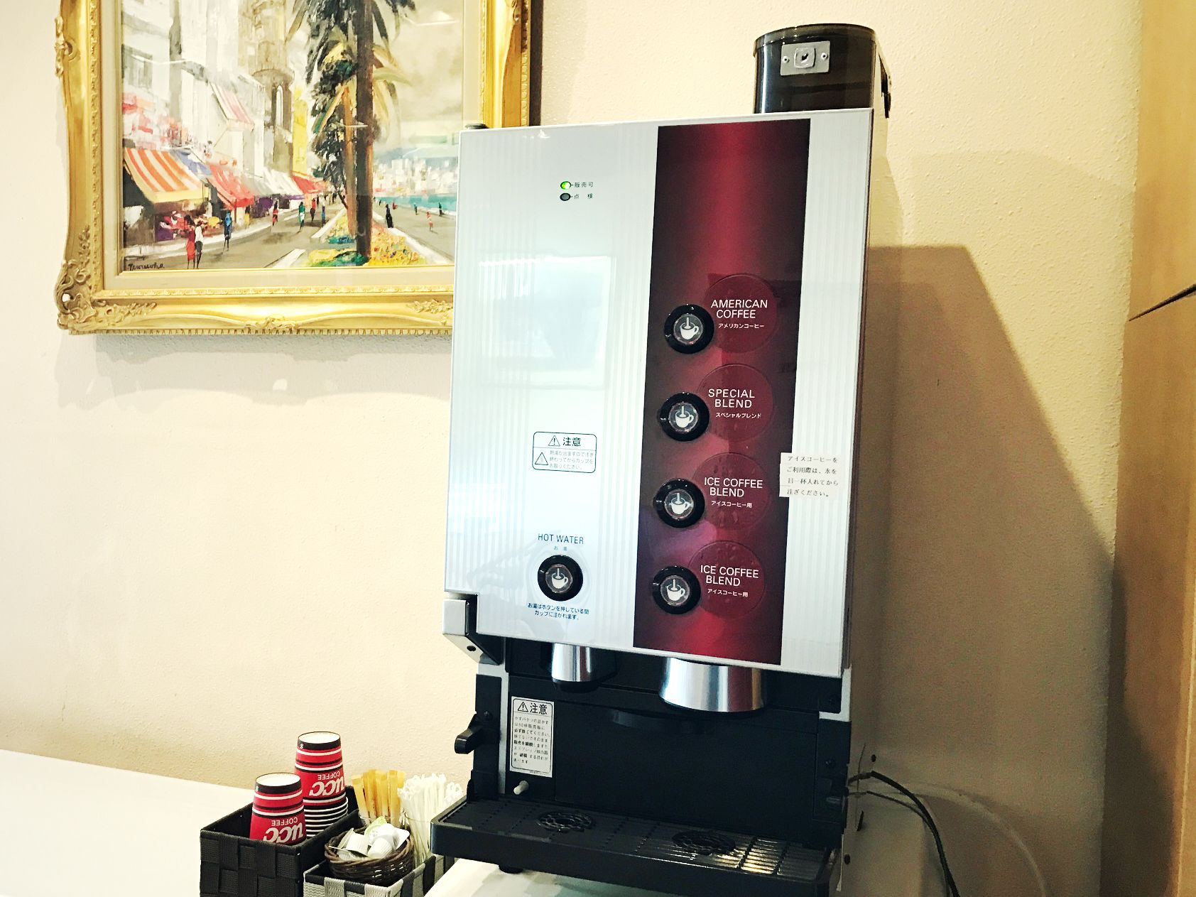 Una cafetera con opciones de café americano, mezcla especial, café helado y agua caliente.