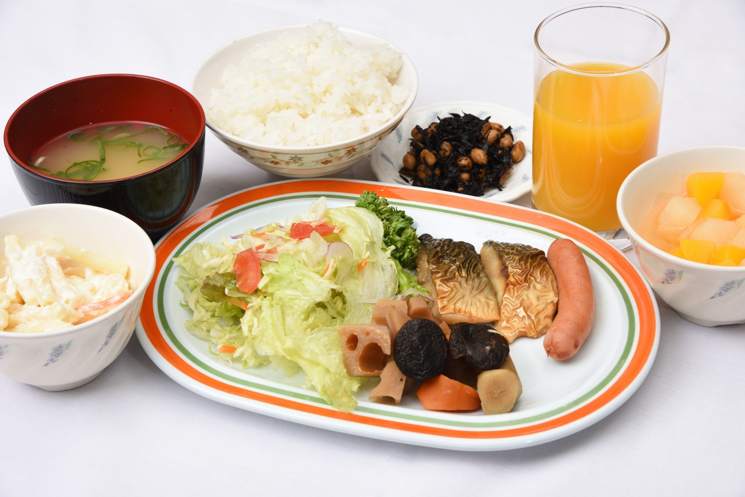 A variety of dishes including rice, soup, salad, and a plate with vegetables and meat.