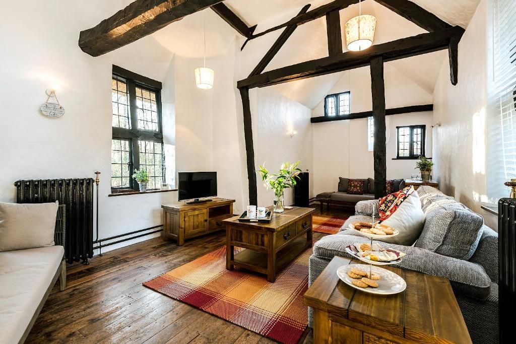 A cozy living room with a wooden floor, a sofa, a coffee table, and a television.