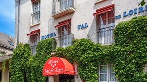 A hotel facade with a red awning, balconies, and ivy-covered walls. - Hôtel Val De Loire (Azay-le-Rideau)