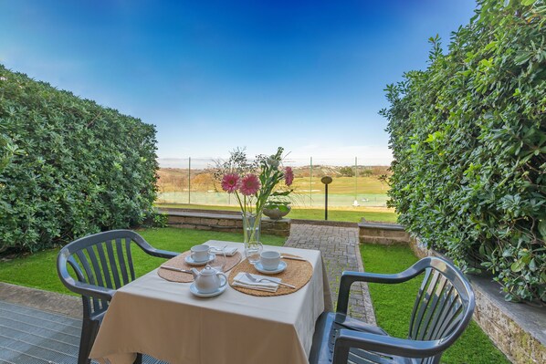 Mesa para dos con vista a un campo de golf.
