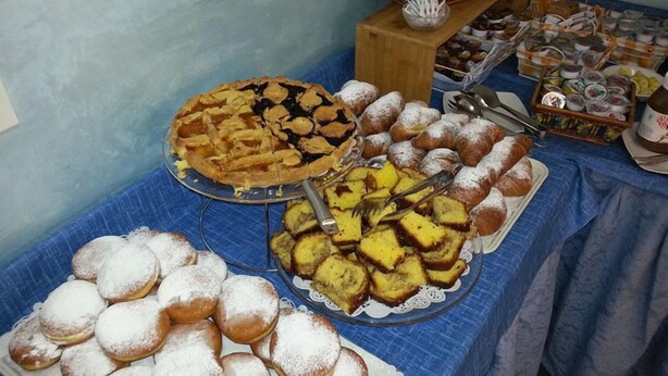 Ein reichhaltiges Buffet mit verschiedenen Backwaren und Desserts, darunter Kuchen, Brötchen und weitere Gebäckstücke.