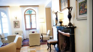 Una habitación tradicional con suelo a cuadros, chimenea y muebles clásicos.