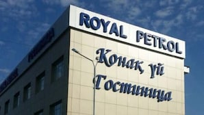 A building with a sign reading "ROYAL PETROL" and "Конак Ю Тосминчка". - Royal Petrol Hotel Taldykorgan (Taldykorgan)