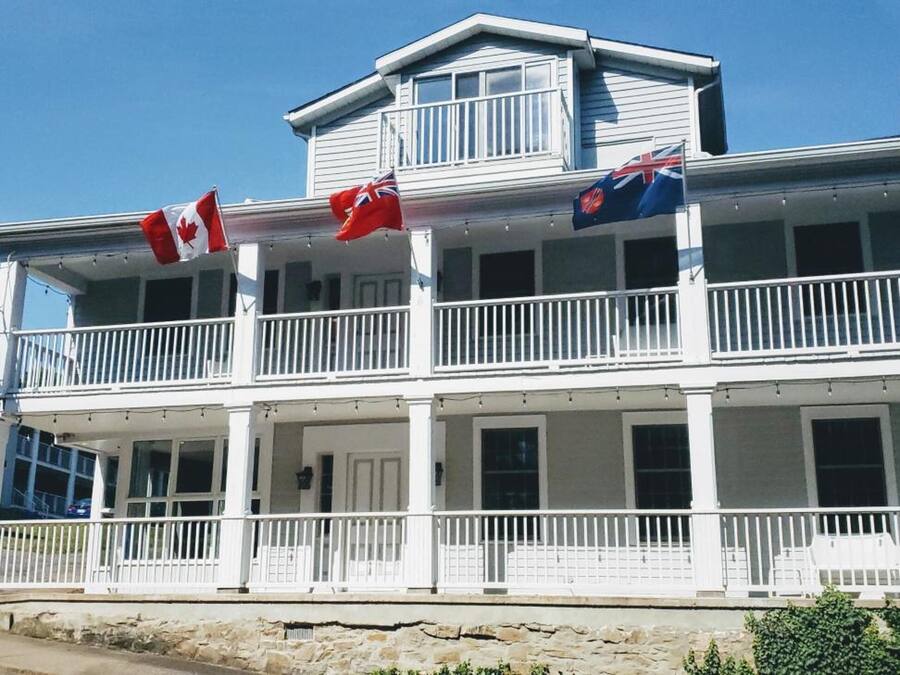 Un bâtiment blanc à deux étages, doté de balcons, de drapeaux et d’une enseigne indiquant qu’il s’agit d’un hôtel Southland Inn.
