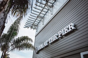 A building with the sign "IN AT THE PIER". - Inn at the Pier Pismo Beach, Curio Collection by Hilton (Pismo Beach)